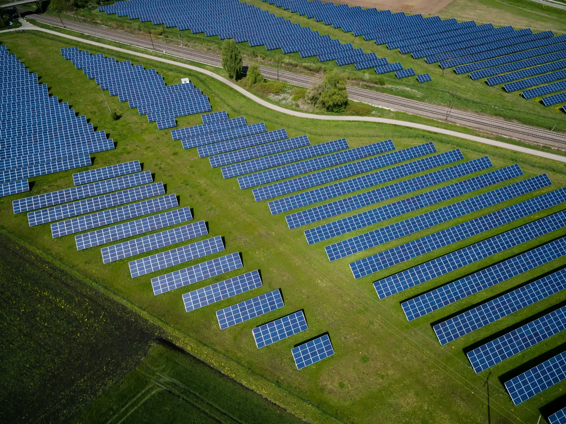 Aerial view of a large solar array on green farmland